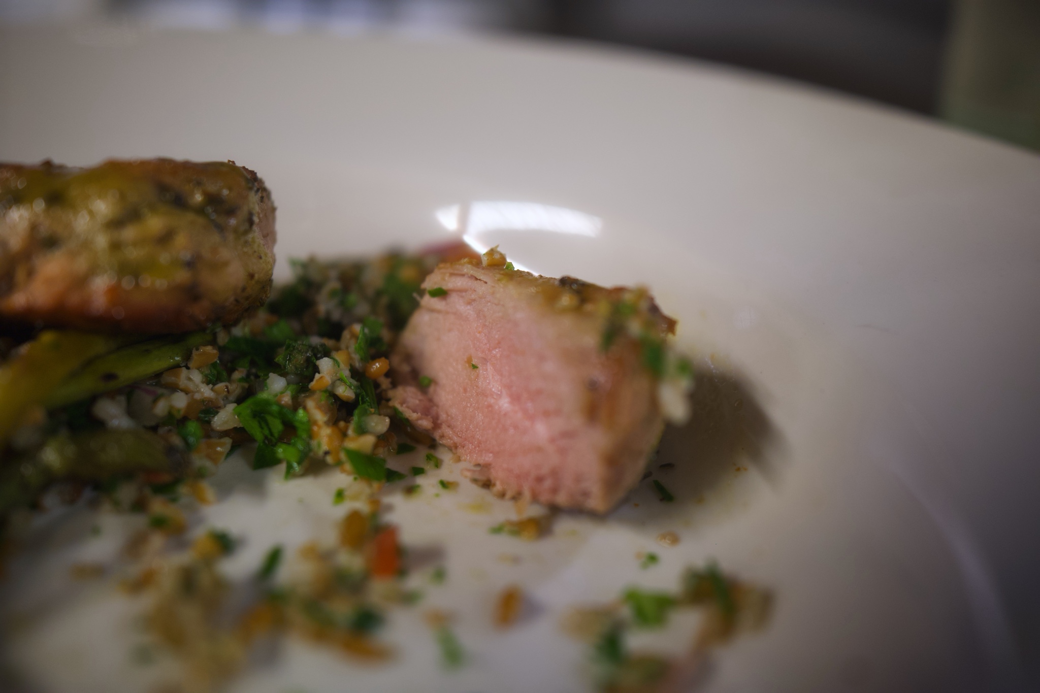 Plate of pork tenderloin with tabbouleh and vegetables.